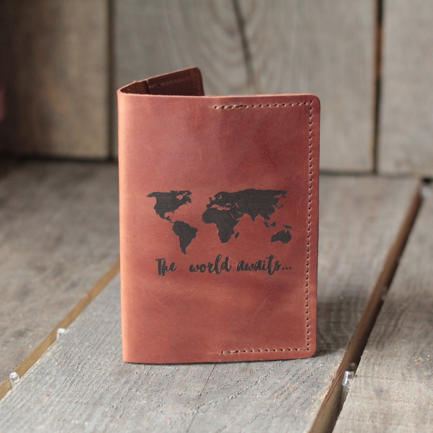 Prezent dla mężczyzny: skórzana okładka w kolorze cognac na tło drewnianego biurka.