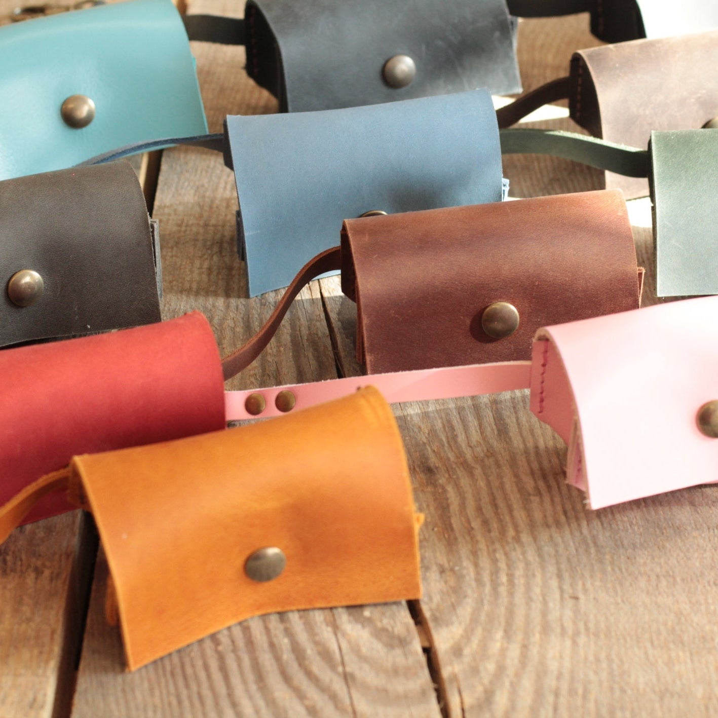 Kobieca dłoń wyjmująca torebkę z eleganckiego, czarnego dispenser z grawerem w kwiaty.