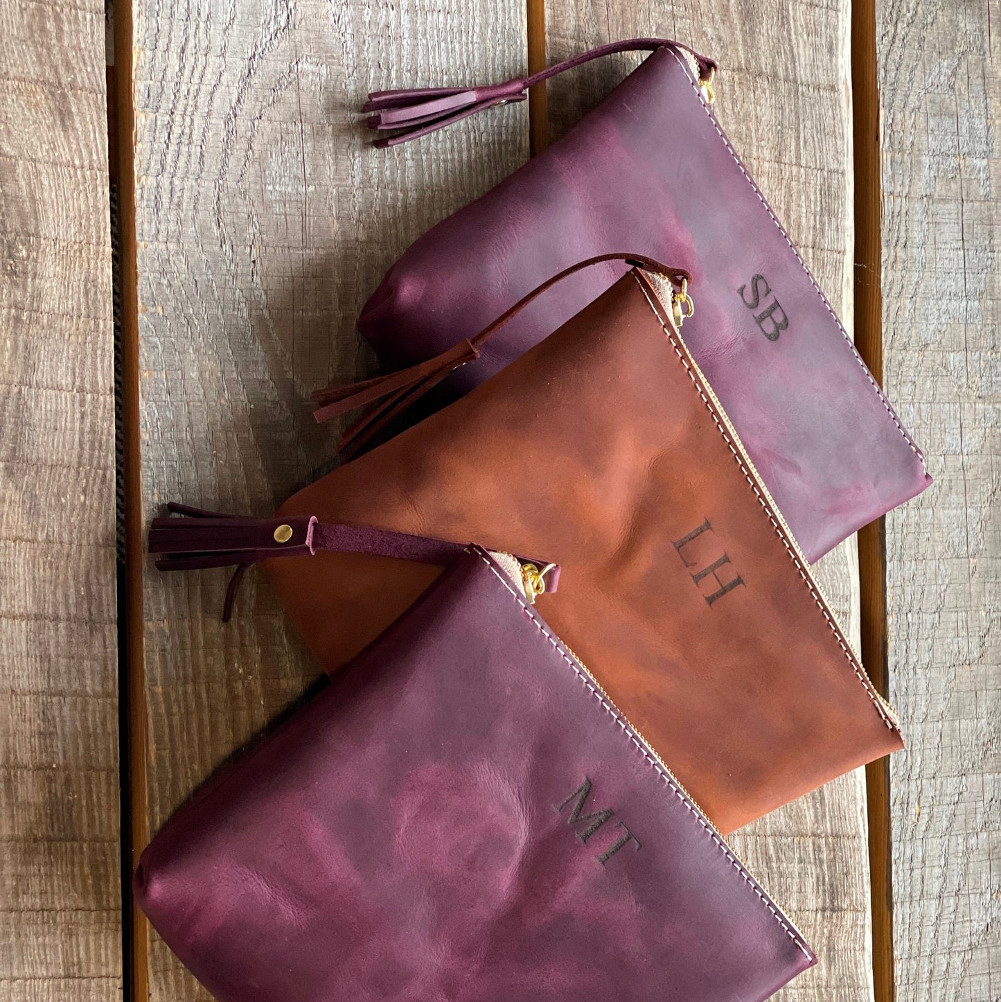 Wnętrze dużej skórzanej kosmetyczki z widocznymi przegródkami na karty i drobiazgi.

