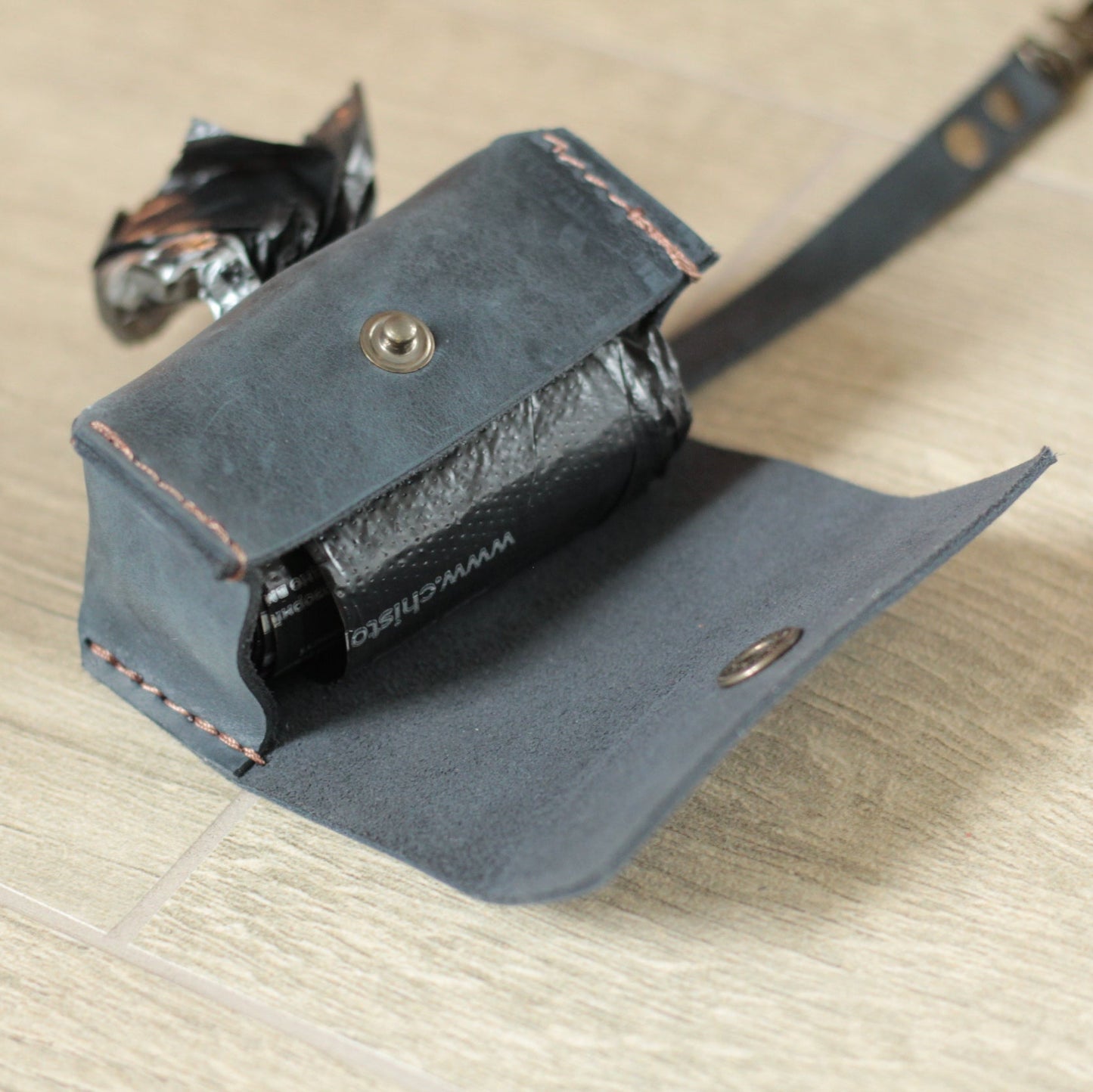 Dispenser przymocowany do obroży psa za pomocą praktycznej zawieszki.

