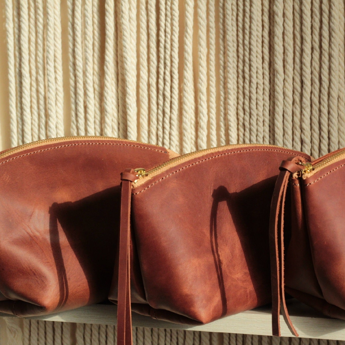 Detal: wysokiej jakości grawer inicjału "A" na skórzanej kosmetyczce.

