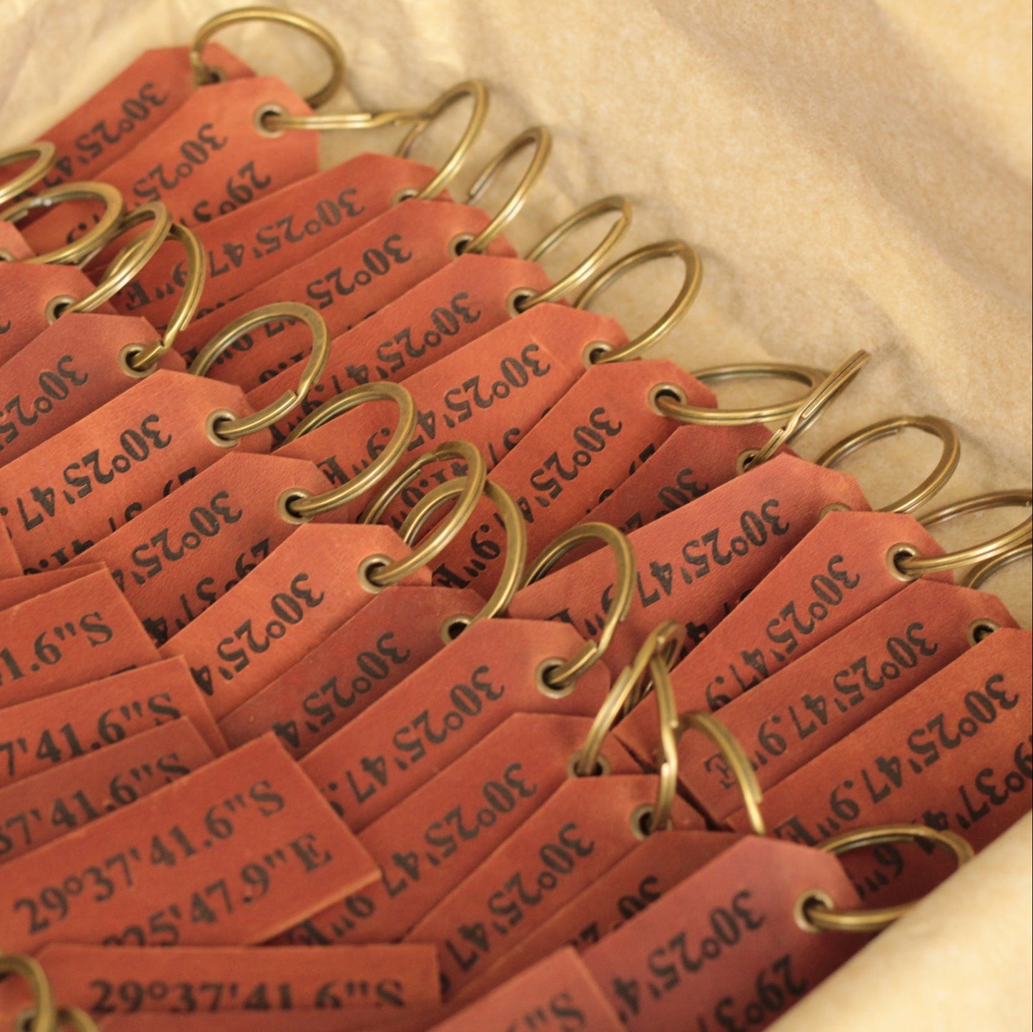 Zbliżenie na grawerowane inicjały na skórzanej etykiecie podróżnej.

