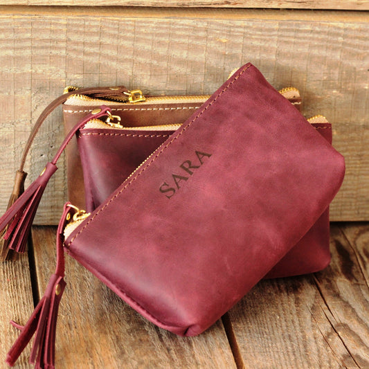 Organizer na biżuterię: otwarta kosmetyczka w rozmiarze Małym z kolczykami i pierścionkami wewnątrz.