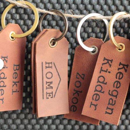 Personalizowana skórzana etykieta na bagaż z wygrawerowanym imieniem „Anna”.

