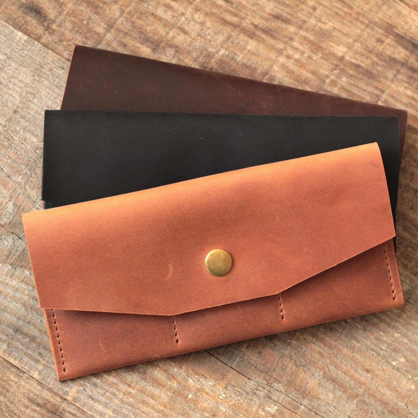 Portfel z włożonym iPhone'em, pokazujący, że telefon mieści się w przegródce.

