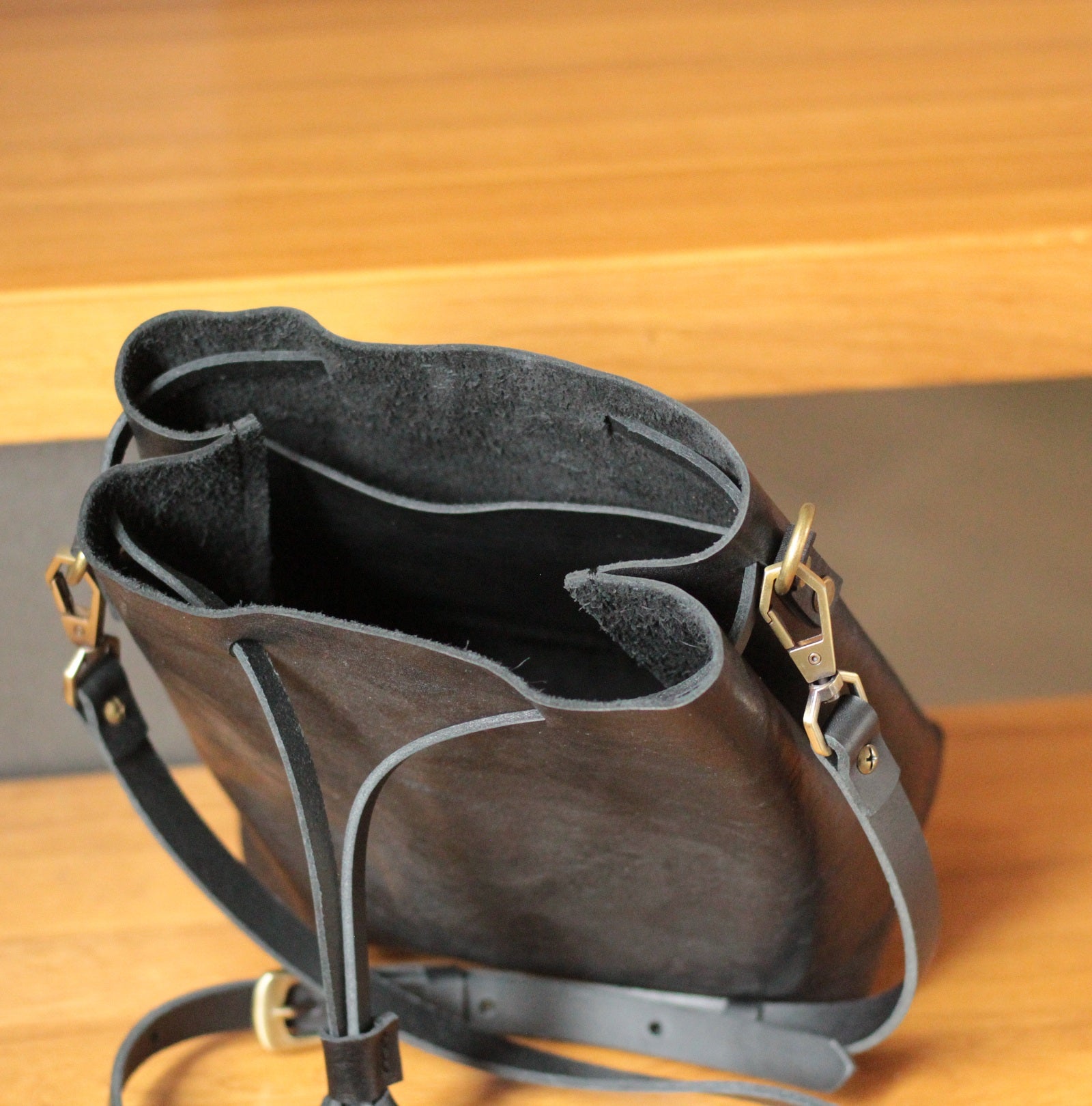 Torba bucket z długimi, skórzanymi rączkami do noszenia na ramieniu.

