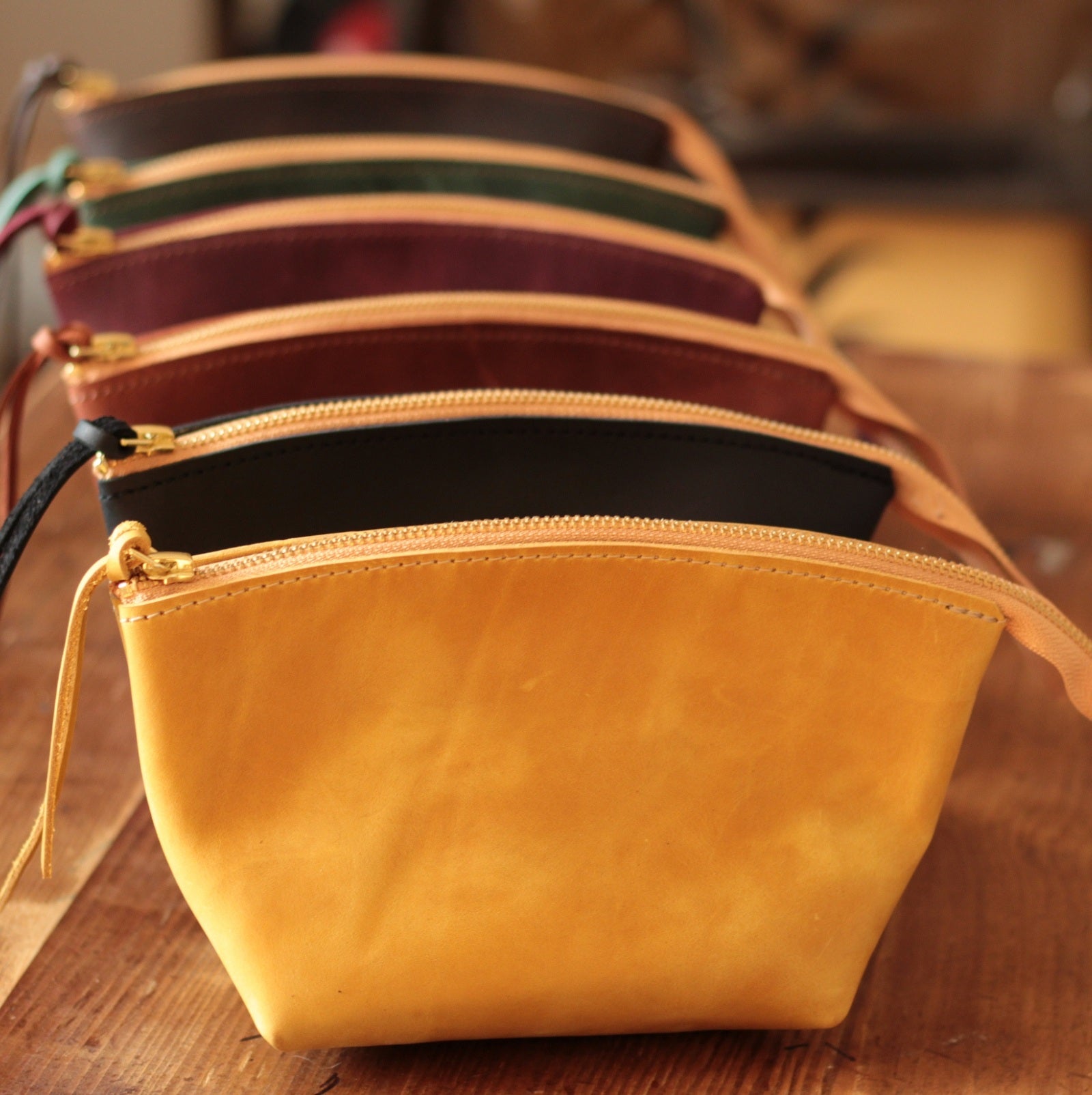 Skórzana kosmetyczka w rozmiarze DUŻYM wypełniona szminkami i pędzlami do makijażu.

