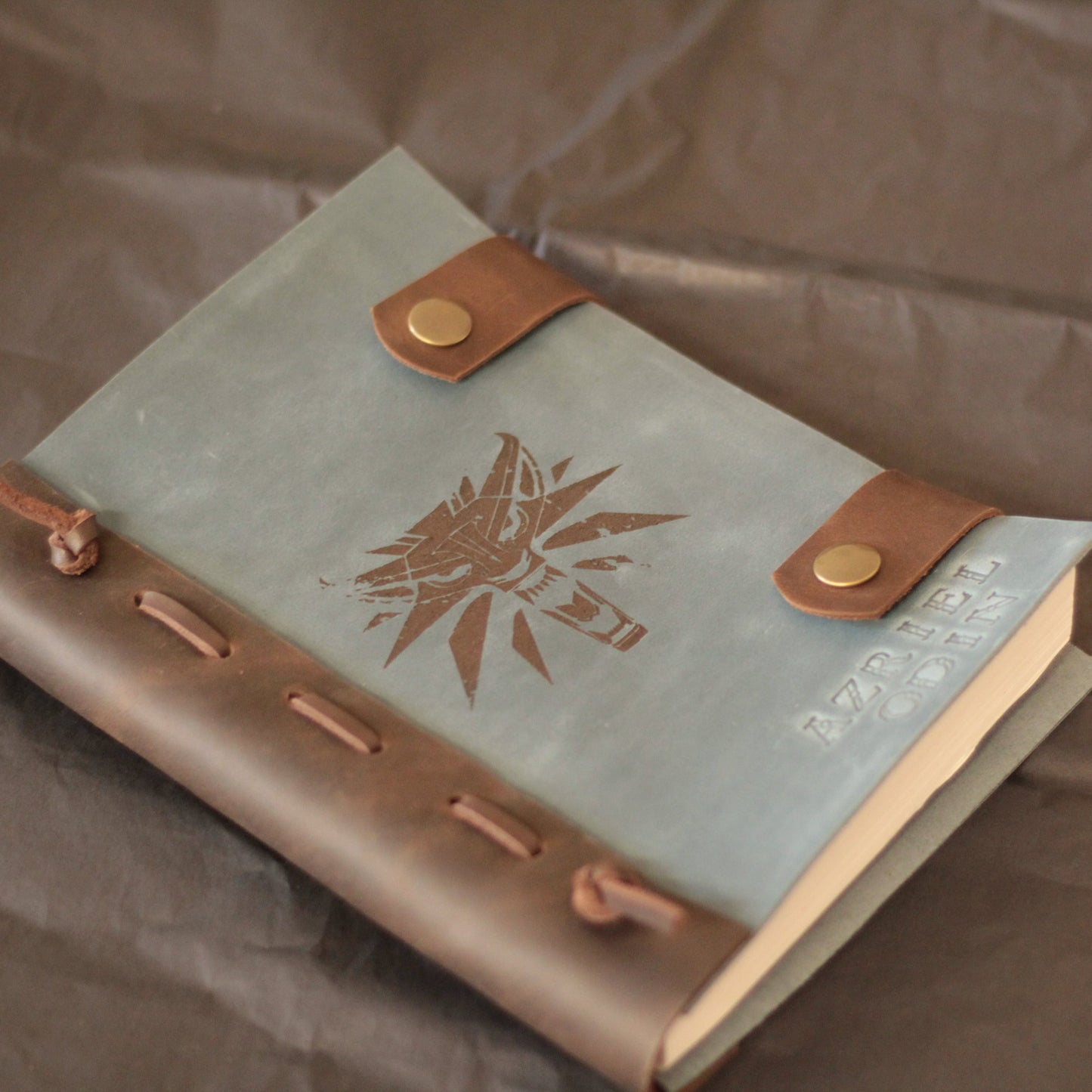 Dłoń pisząca piórem wiecznym na czystej stronie beżowego papieru kraft w dzienniku.

