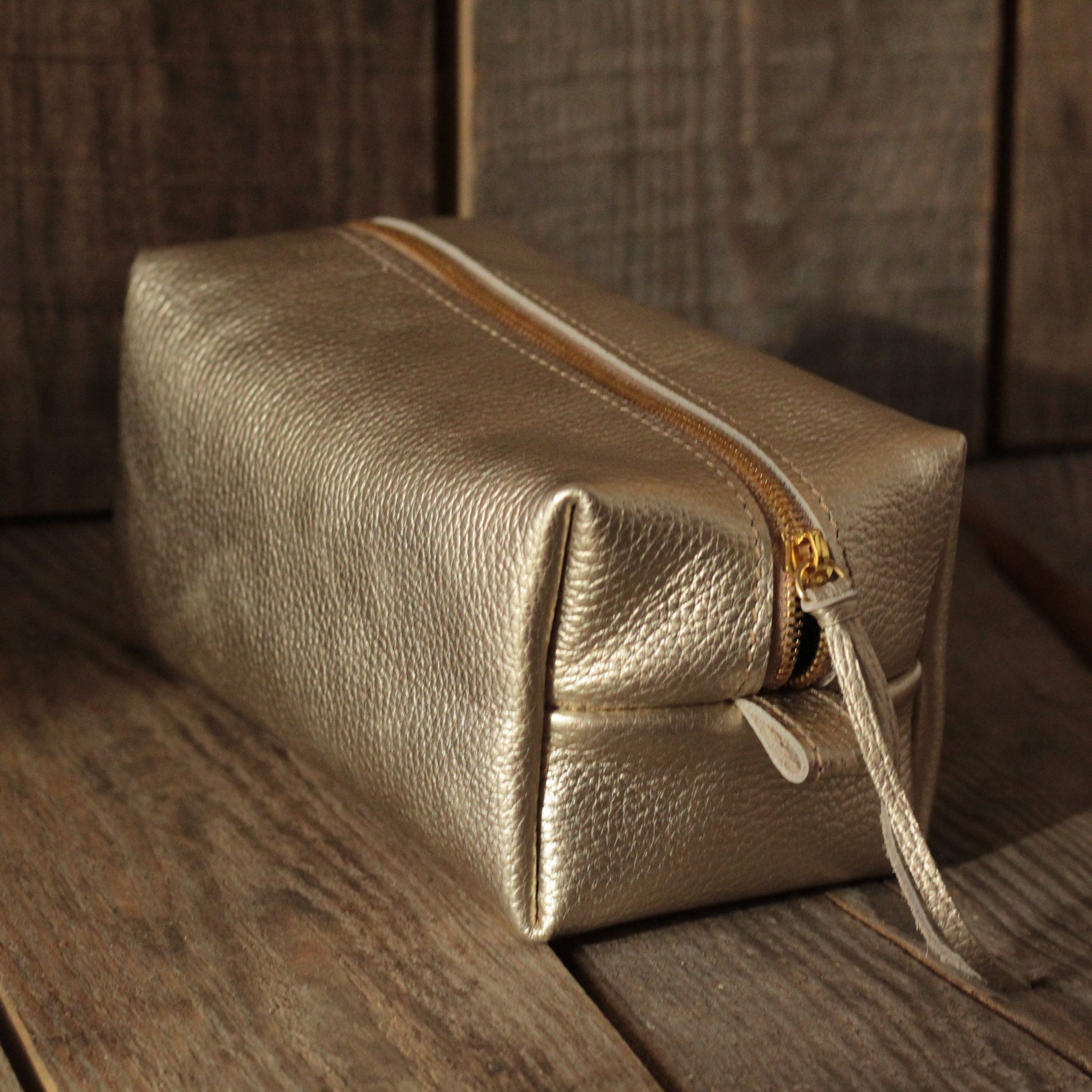 Elegancka miękka torba na kosmetyki z zamknięciem na zamek w kolorze beżowym.

