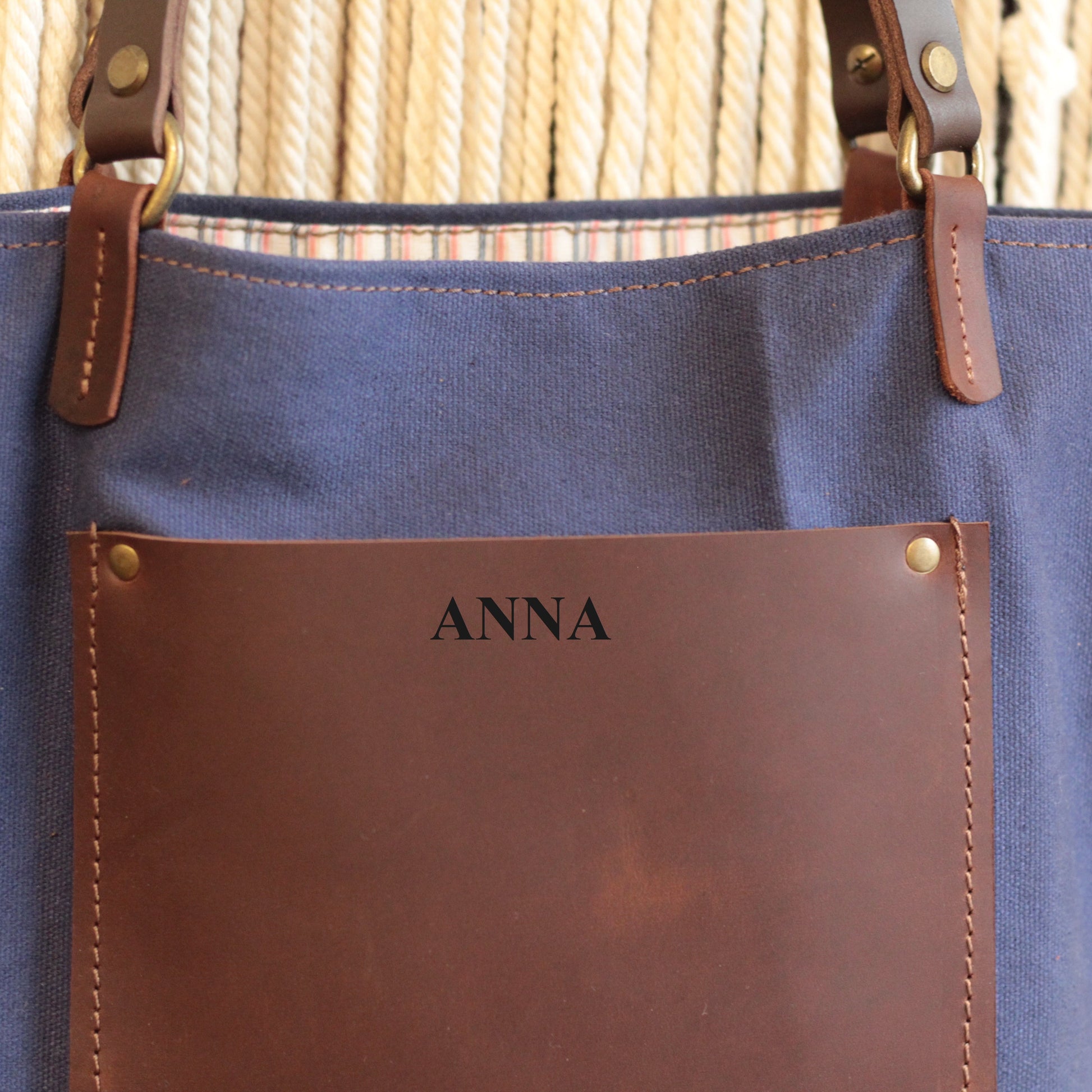 Torba waxed canvas z widoczną, praktyczną skórzaną kieszenią z boku.

