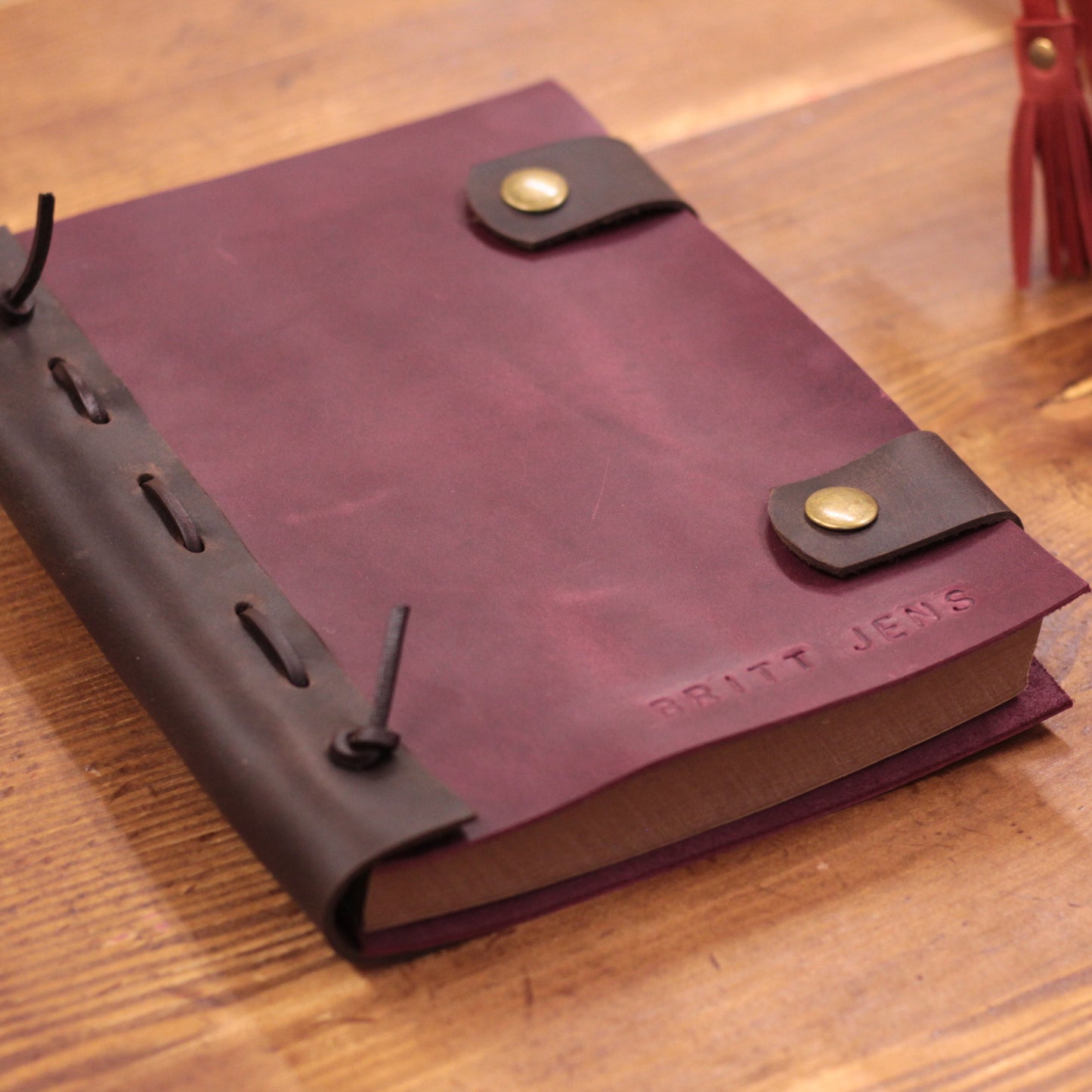 Zbliżenie na fakturę i szwy wysokogatunkowej skóry na okładce notesu.

