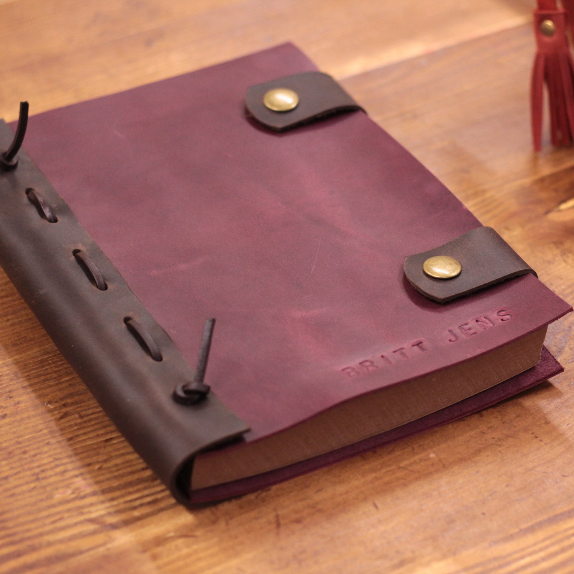 Zbliżenie na fakturę i szwy wysokogatunkowej skóry na okładce notesu.

