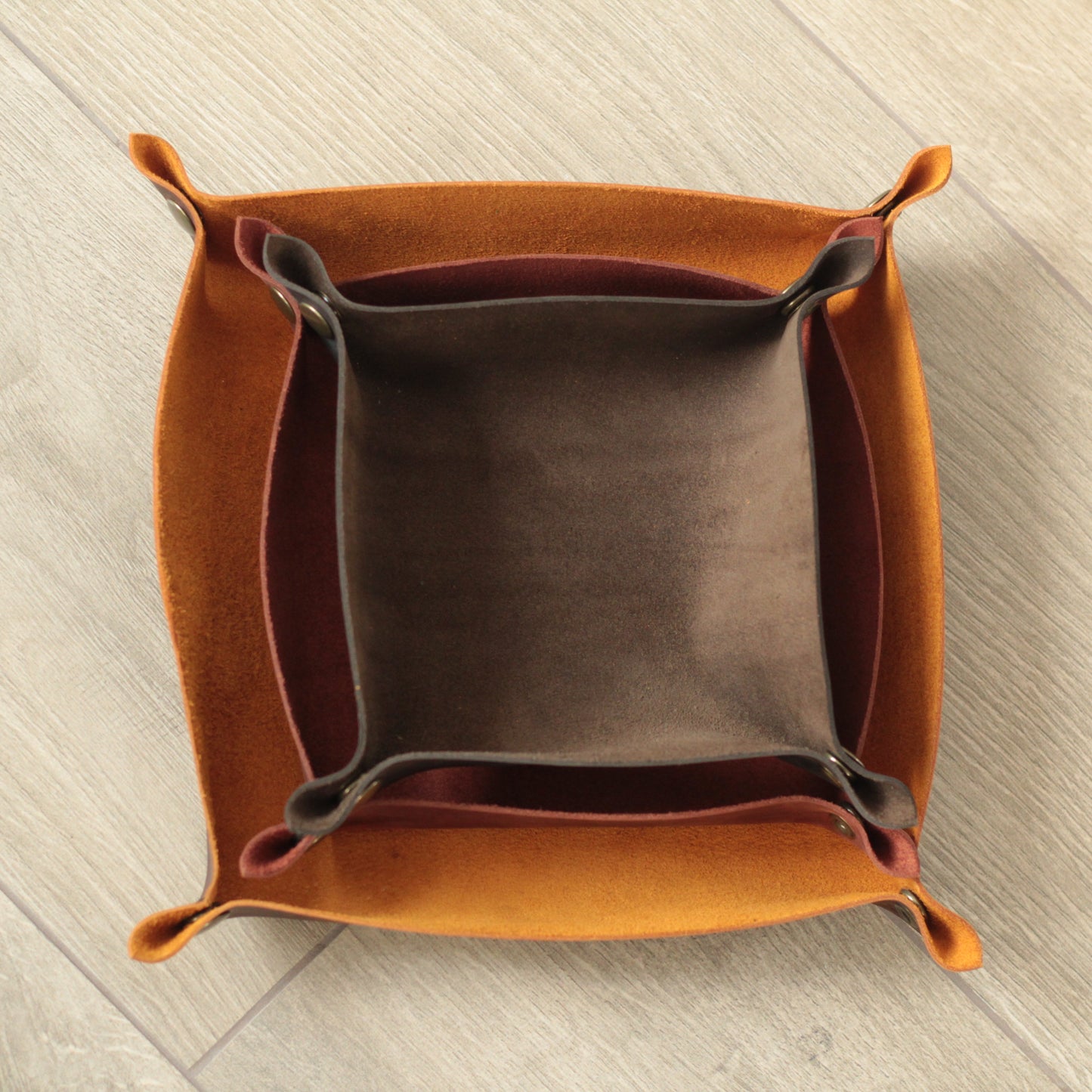 Gładka, skórzana podstawa z wygrawerowanym monogramem. Zapewnia porządek i styl na powierzchni.