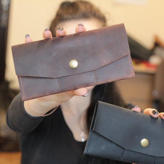 Spersonalizowany skórzany portfel z zamkniętym zatrzaskiem i grawerem inicjałów.

