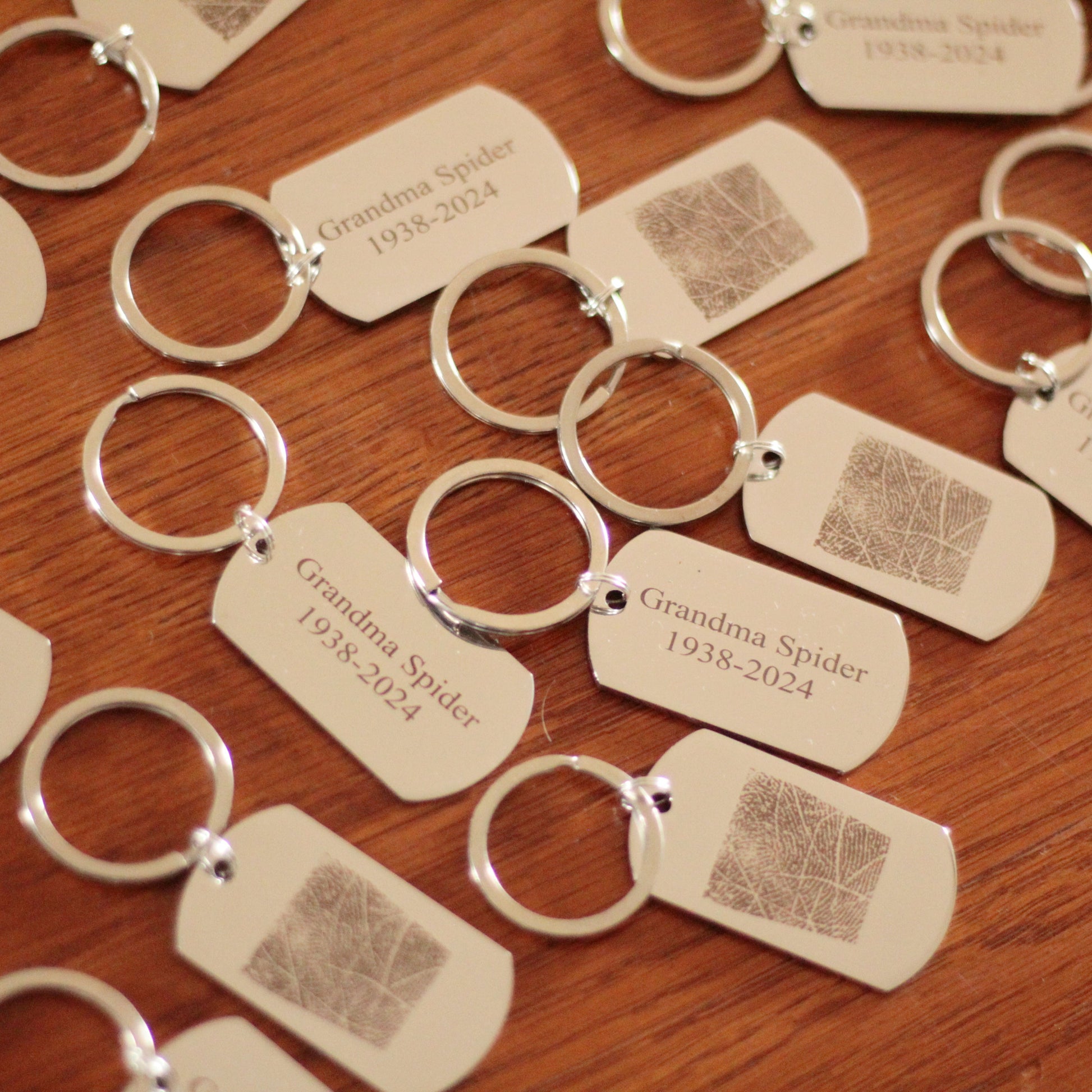 Brelok z odciskiem palca trzymany w dłoni obok kluczy - idealny, dyskretny rozmiar 50x28 mm.

