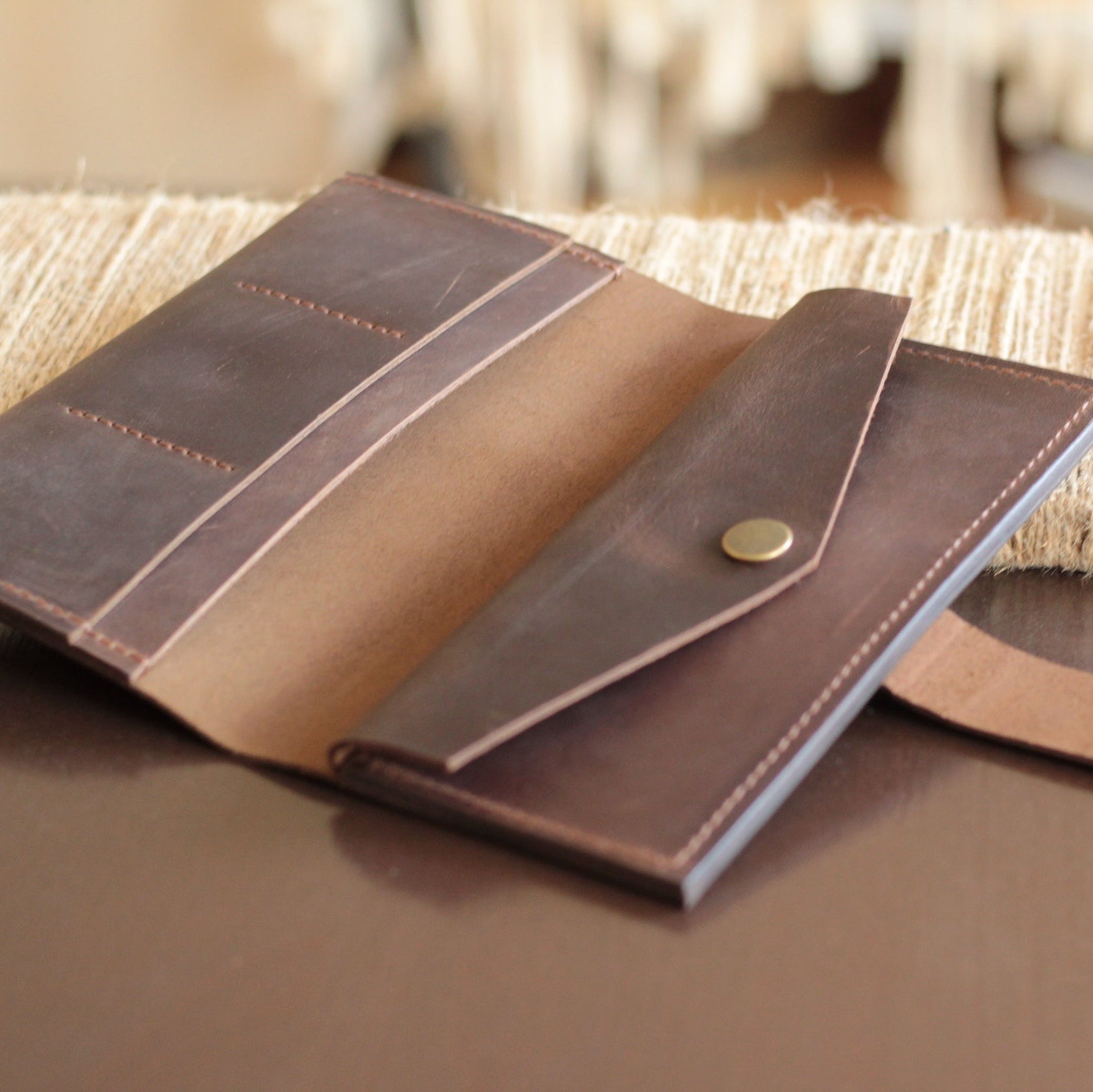 Portfel zamknięty na zatrzask, leżący w małej, eleganckiej damskiej torebce.

