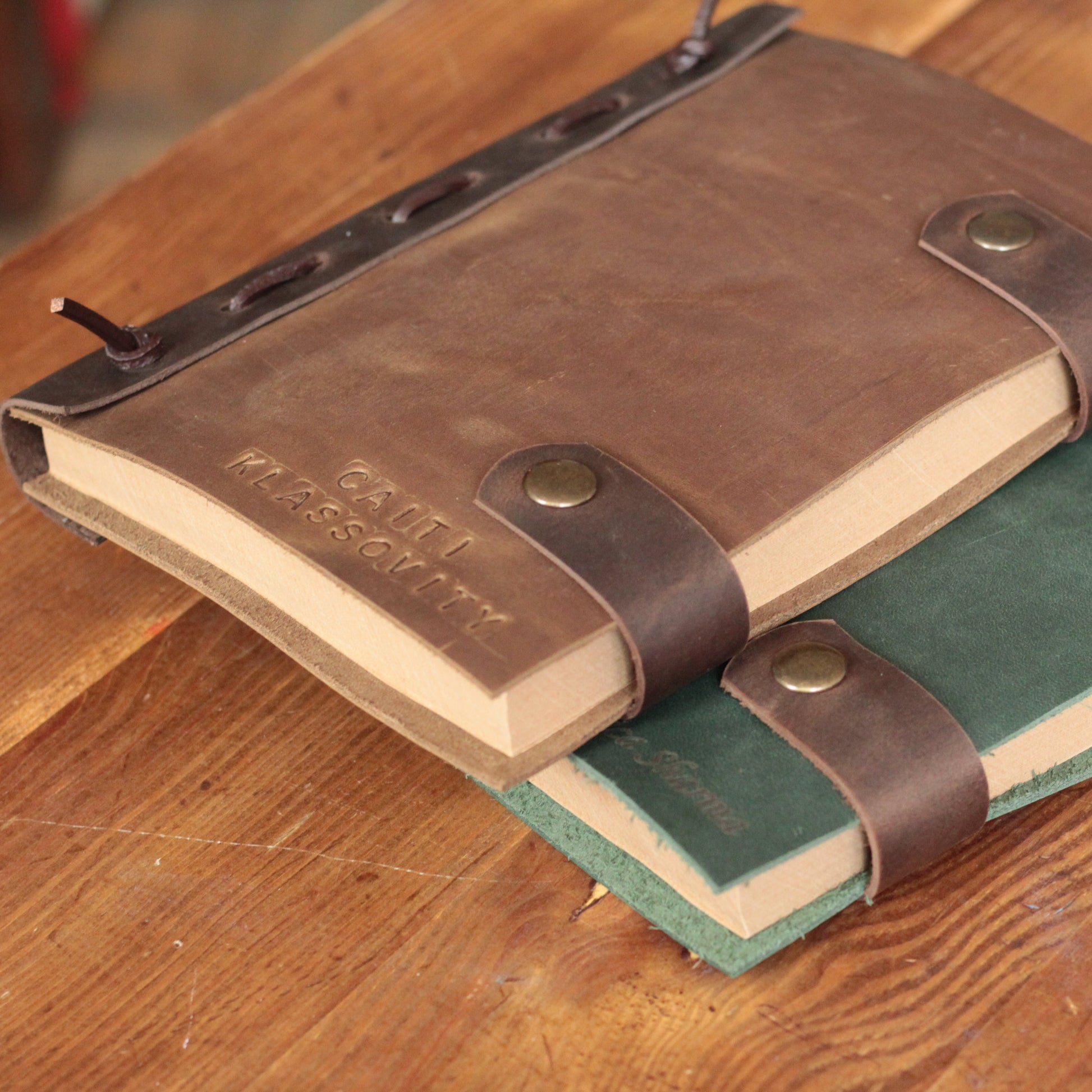 Zbliżenie na wysokiej jakości laserowy grawer napisu "Dziennik Wdzięczności" na skórzanej okładce.

