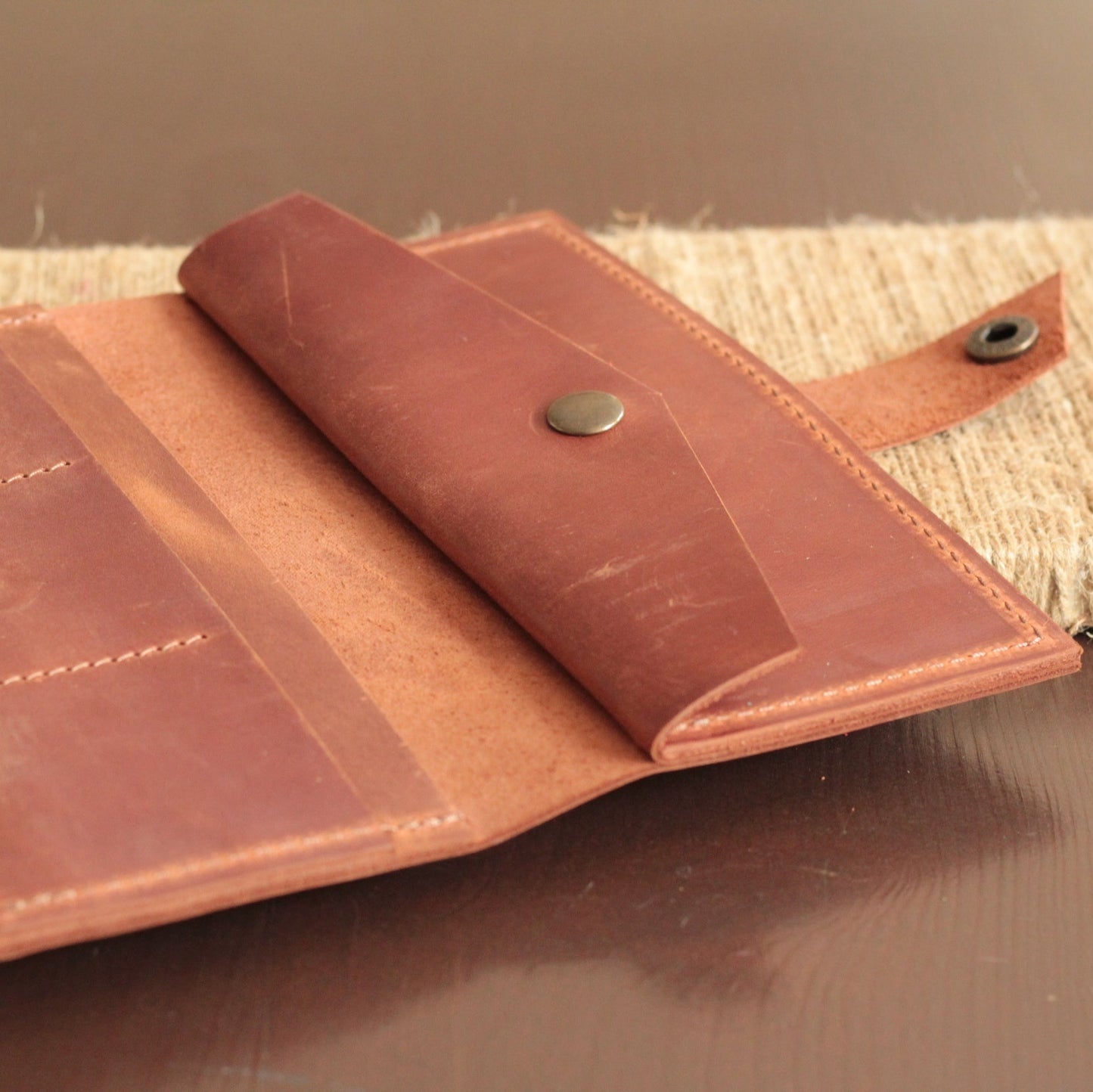 Portfel damski na tle kobiecej galanterii (apaszka, rękawiczki).

