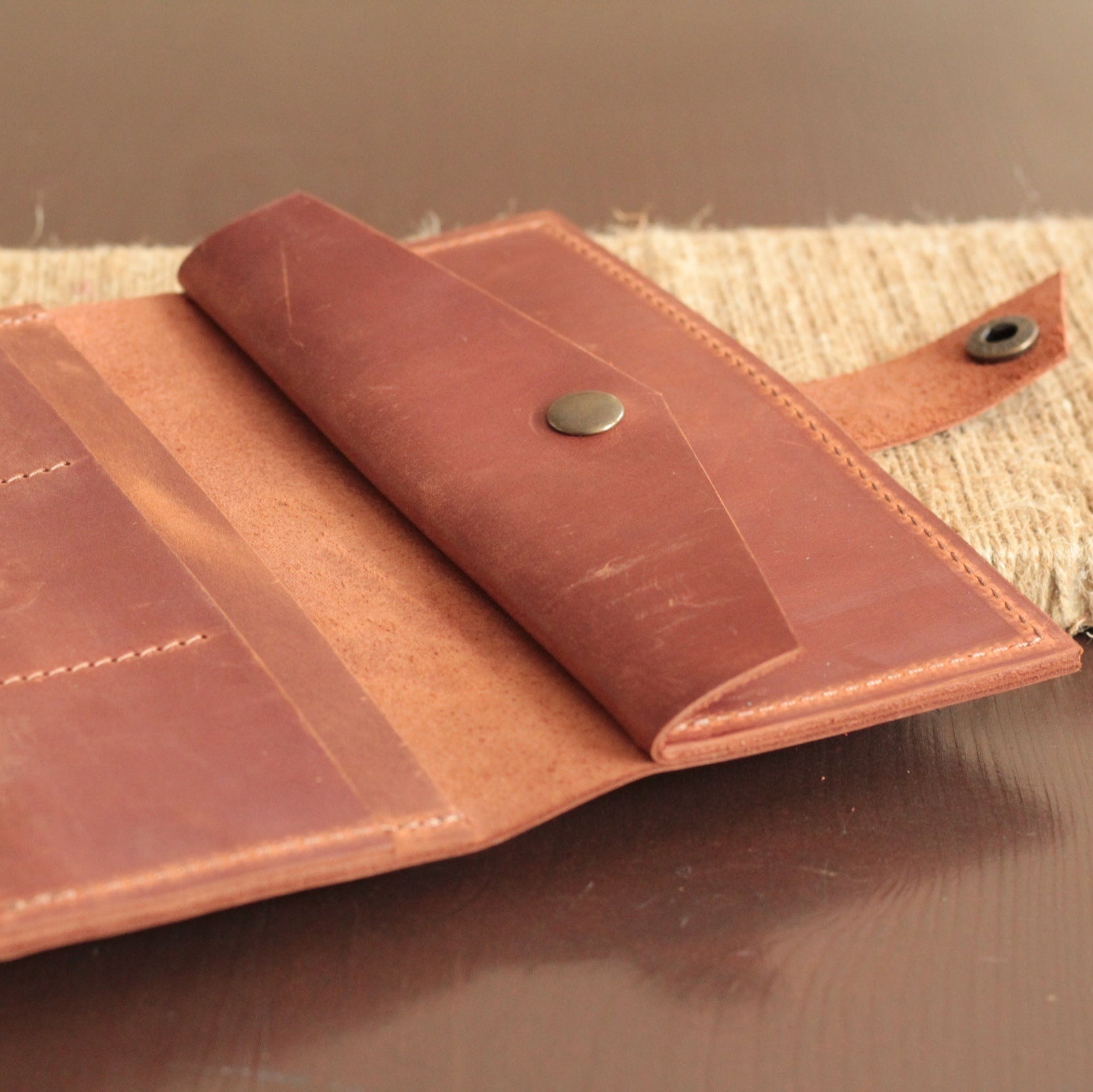 Portfel damski na tle kobiecej galanterii (apaszka, rękawiczki).

