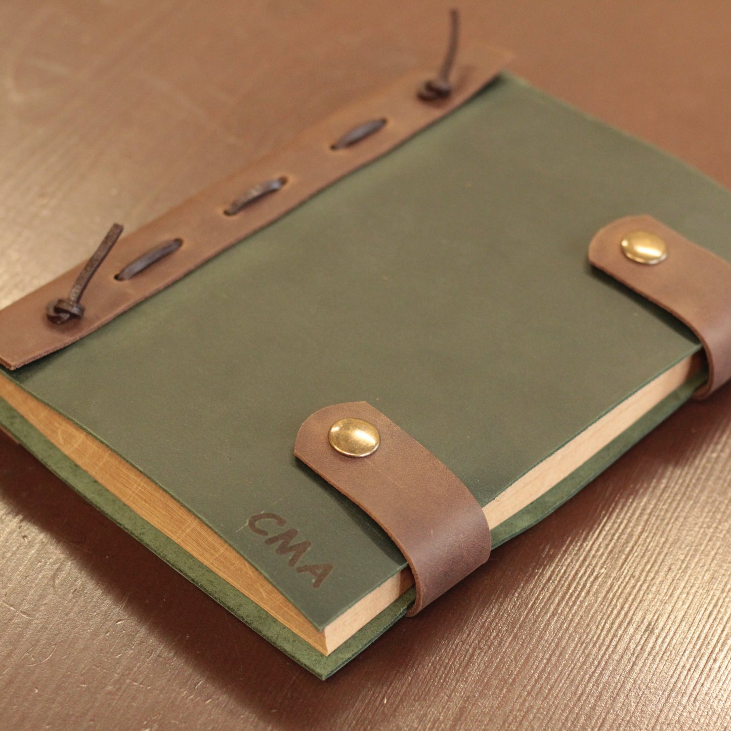 Ręka otwierająca opakowanie prezentowe z widocznym spersonalizowanym notesem w środku.

