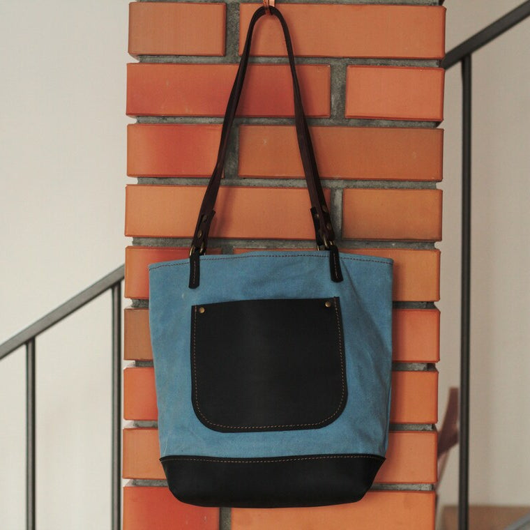 Krople wody spływające po powierzchni woskowanej torby – demonstracja wodoodporności.


