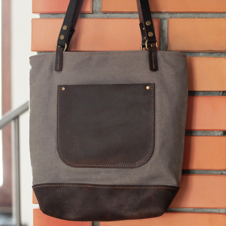 Zbliżenie na łączenie skórzanej kieszeni z płótnem – detale rzemieślnicze.

