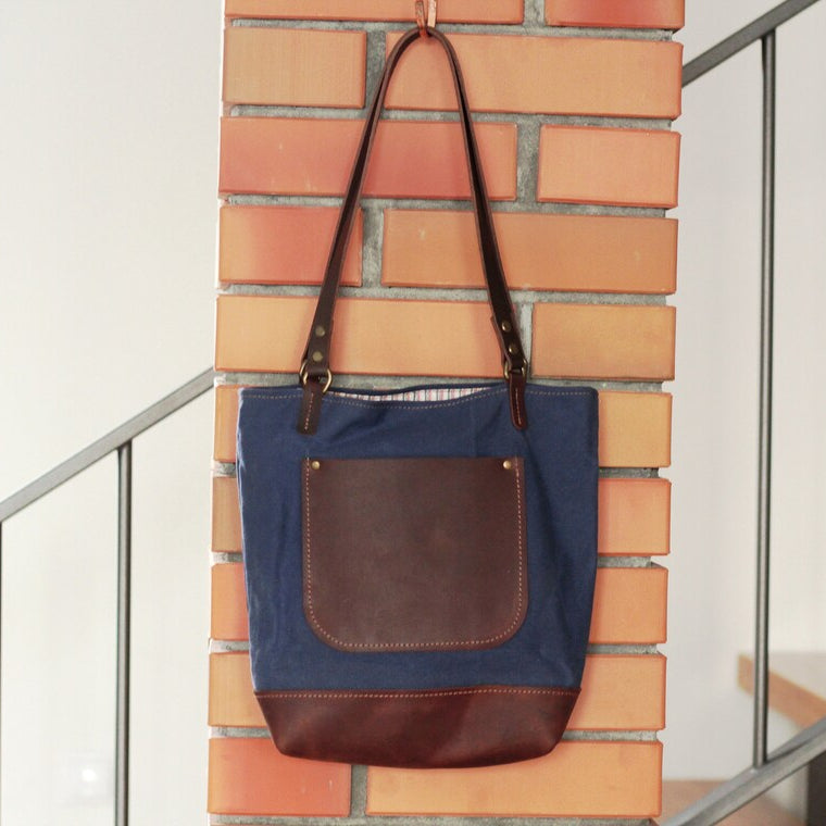 Torba z włożonym laptopem i notatnikiem, jako torba do pracy lub na uczelnię.

