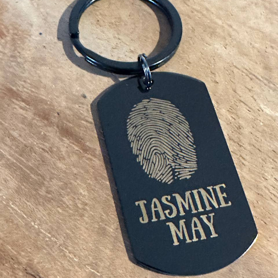 Zbliżenie precyzyjnego grawerunku odcisku palca na breloku personalizowanym - unikalny wzór.

