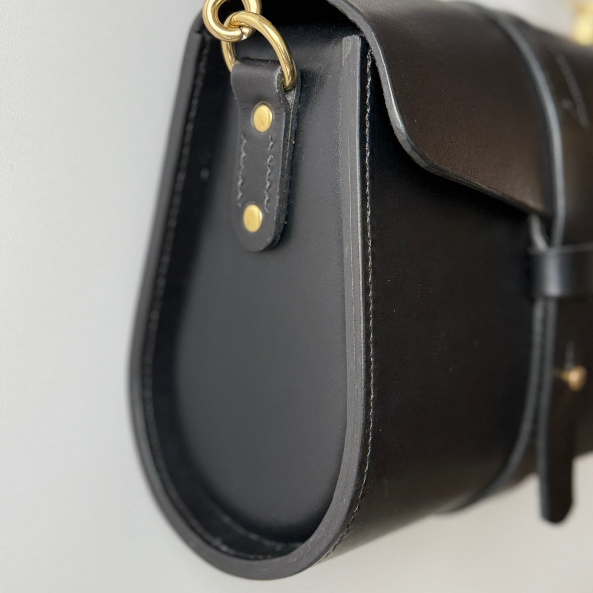 Zbliżenie na charakterystyczne, ręczne szwy wykonane grubą, woskowaną nicią.

